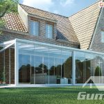 Eine Überdachung des Terrassenbereichs mit Polycarbonat von Gumax, ergänzt durch verschiebbare Glaswände, bildet eine elegante Struktur für den Wohnbereich auf der Terrasse.